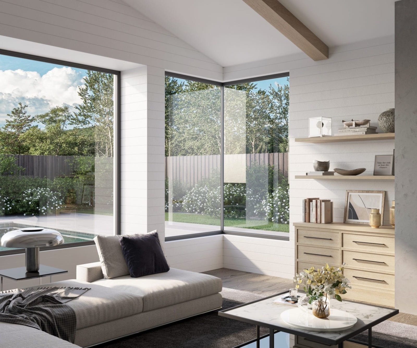 Bright living room with black-framed corner windows overlooking the garden and pool