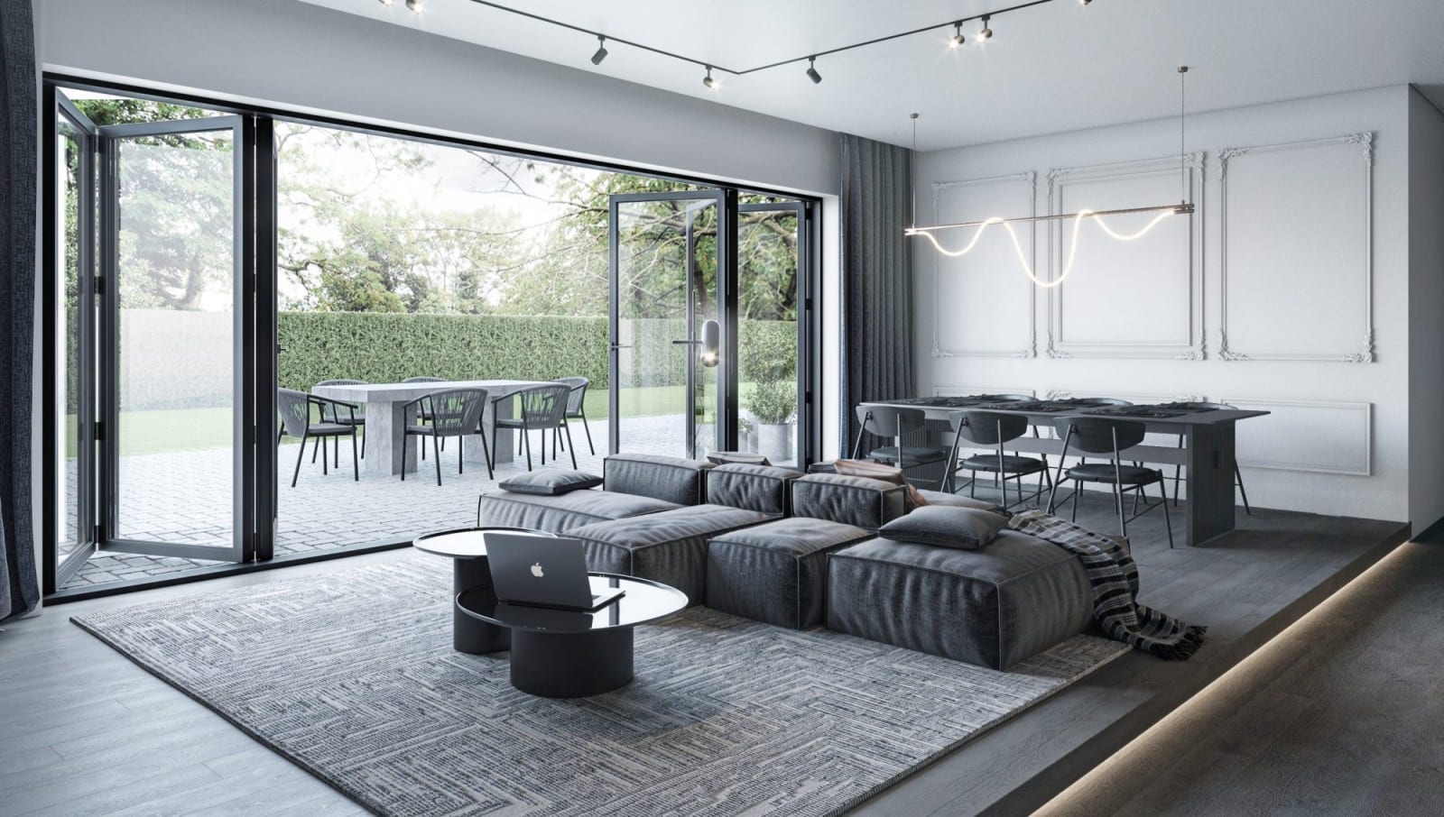 White living room with black bifold accordion doors open onto a courtyard