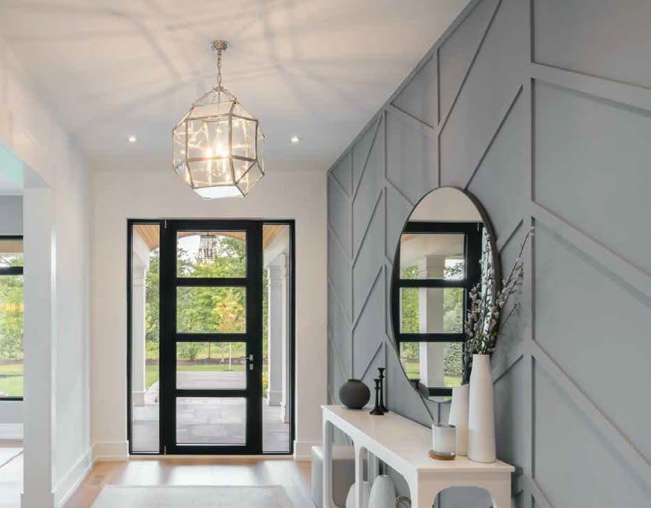 White vestibule with a black glazed entry door and a hanging lantern