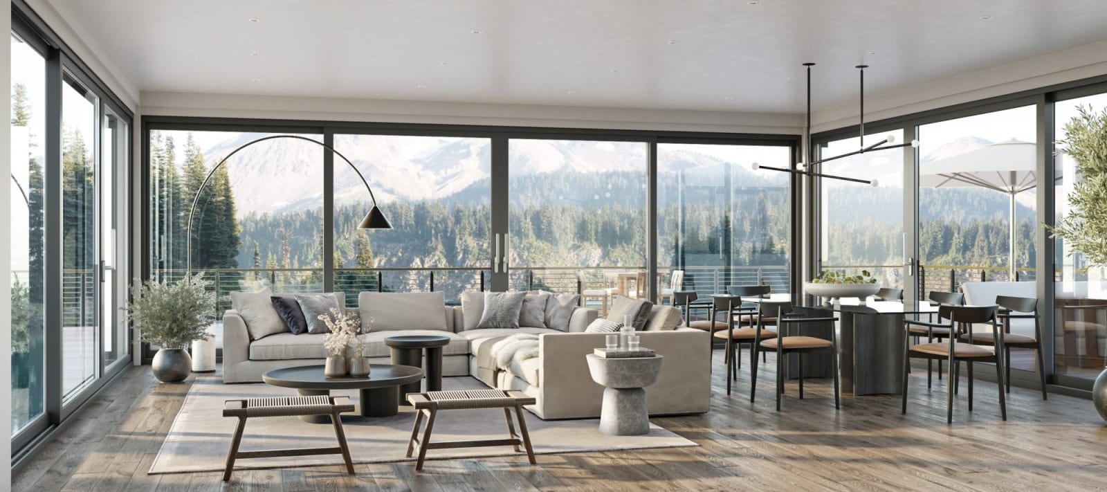 Living and dining area surrounded by glazed lift-and-slide doors with a forest view