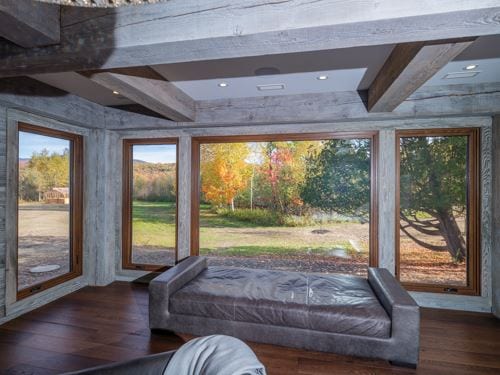 Wood-framed casement window in a rustic living room