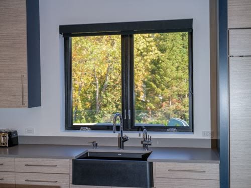 Black casement window above a kitchen sink