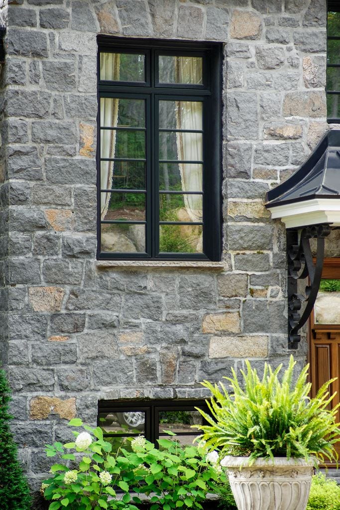 Dark-framed casement window on a stone wall