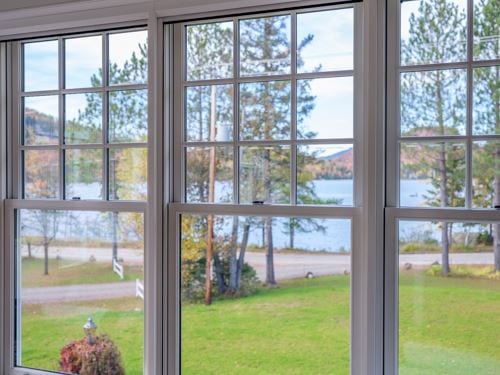 Grey-framed double-hung windows with grilles, lake view