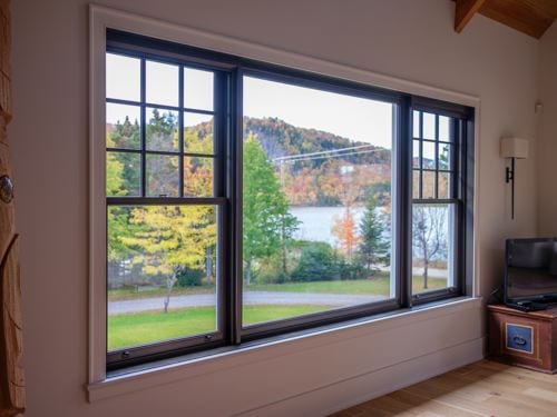 Black double-hung window with a lake and mountain view