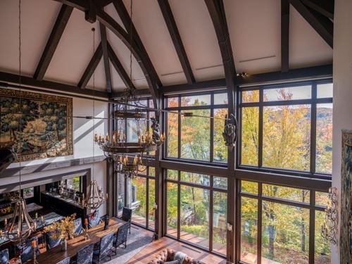 Large wood fixed windows in a rustic living room with a view