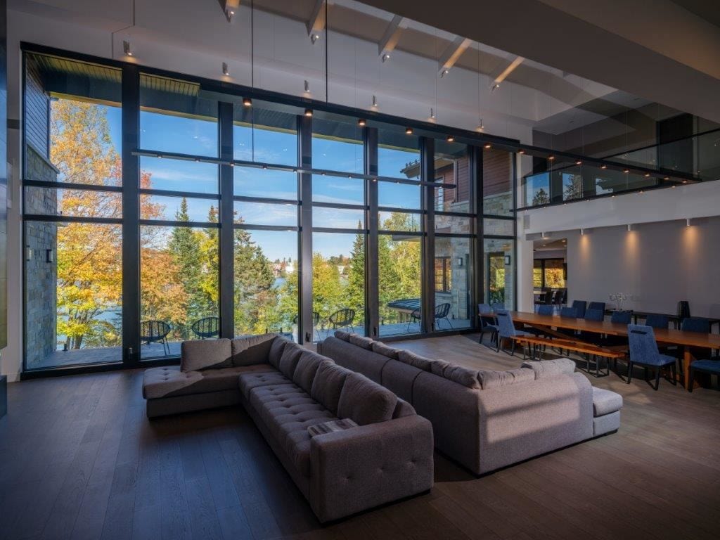Living room with large Lepage Millwork fixed windows facing the forest