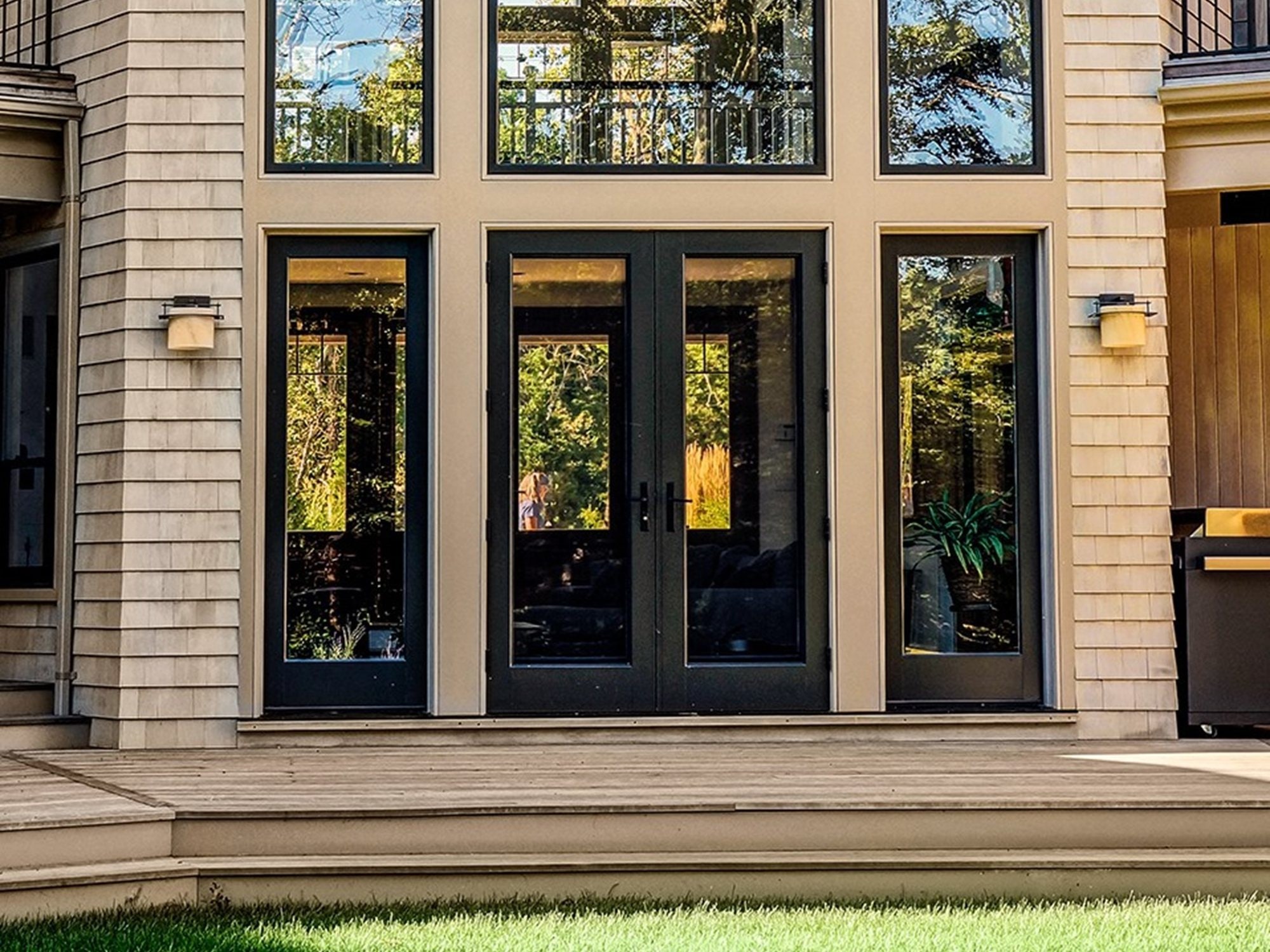 Lepage Millwork wood french door finished in black, with transom and full height windows