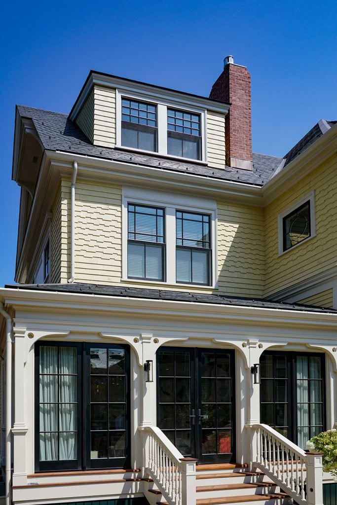 Black French door on the ground floor of a three storey facade