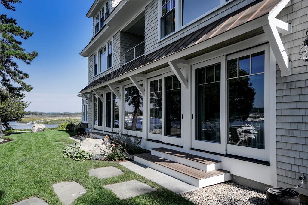 White lift-and-slide door seen from outside, seaside home
