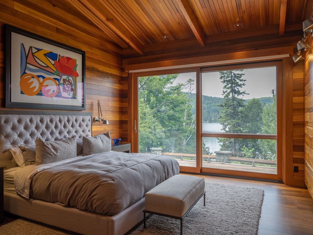 Wood lift-and-slide door in a bedroom with a cedar ceiling