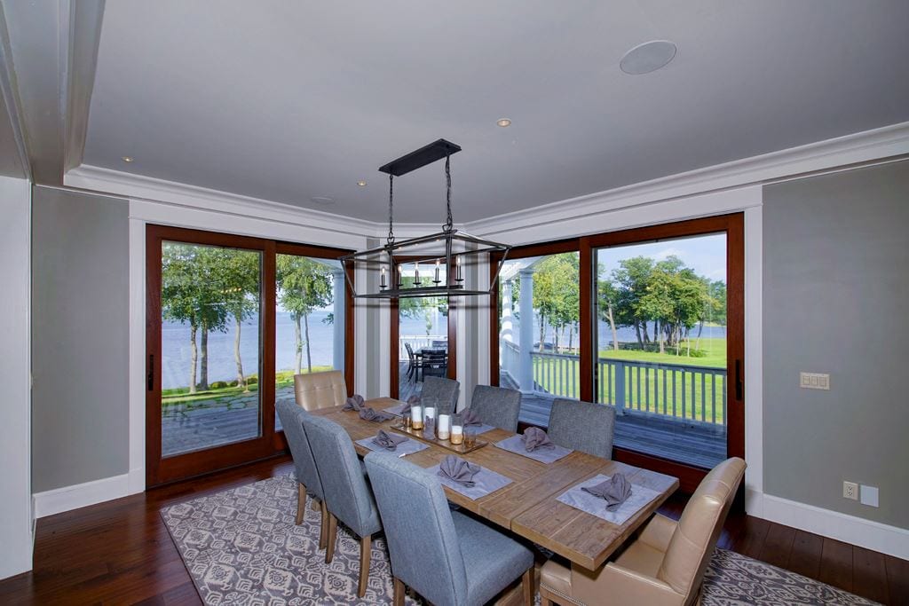 Wood lift-and-slide door in a dining room with a water view